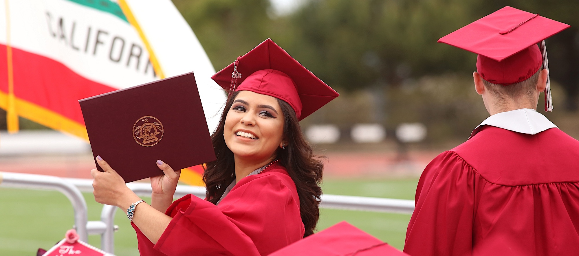 MPC Student Holding Up Diploma at Graduation Ceremony